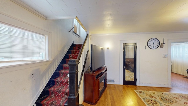 interior space with crown molding and light wood-type flooring