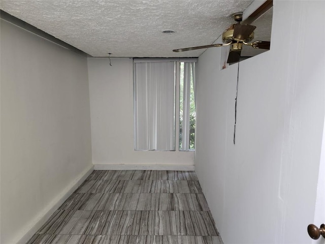 spare room featuring a textured ceiling and ceiling fan