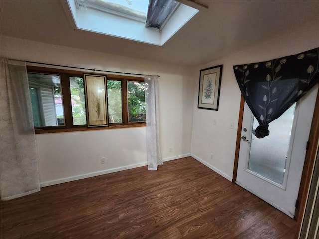 unfurnished room featuring lofted ceiling with skylight and dark hardwood / wood-style flooring