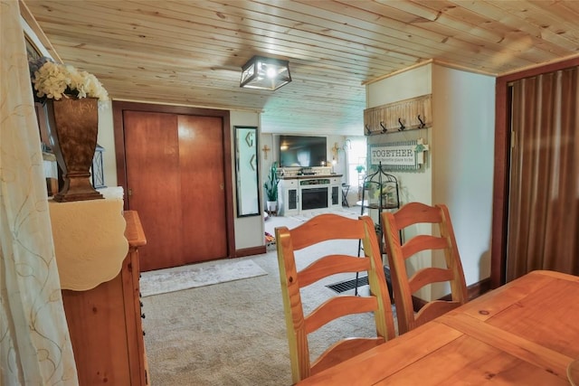 dining area featuring light colored carpet and wood ceiling