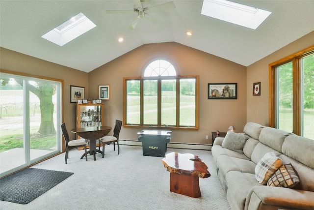 living room featuring light carpet, baseboard heating, lofted ceiling with skylight, and ceiling fan