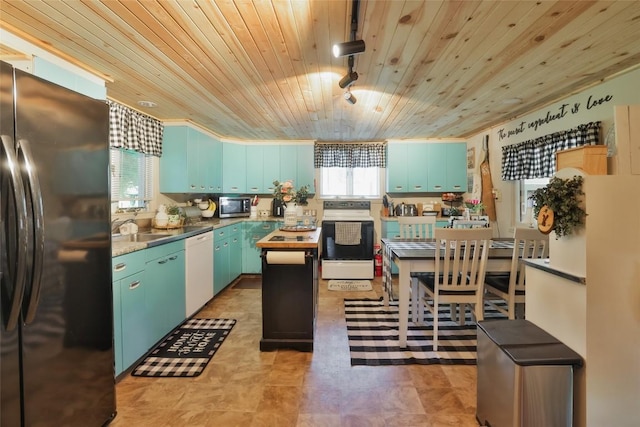 kitchen with a center island, sink, rail lighting, appliances with stainless steel finishes, and wood ceiling