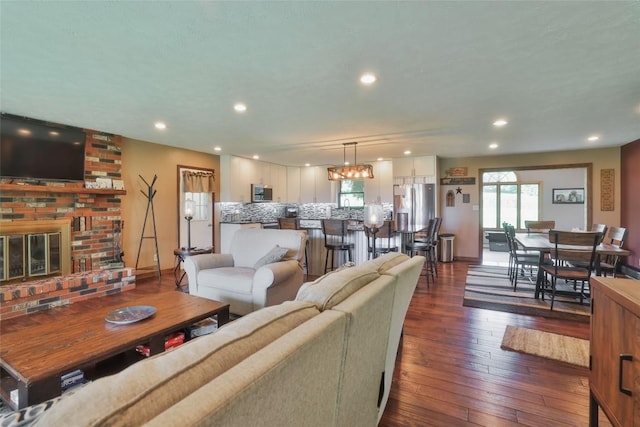 living room featuring dark hardwood / wood-style floors and a brick fireplace