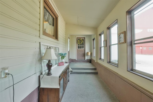 interior space featuring dark carpet and vaulted ceiling