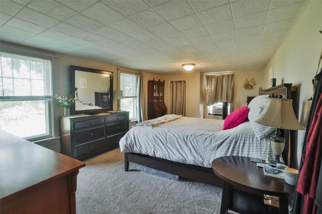 bedroom with light colored carpet, multiple windows, and cooling unit