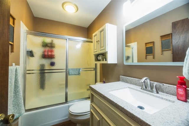 full bathroom featuring vanity, toilet, and shower / bath combination with glass door