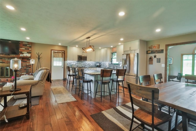 kitchen with a kitchen breakfast bar, hanging light fixtures, a kitchen island, and stainless steel appliances