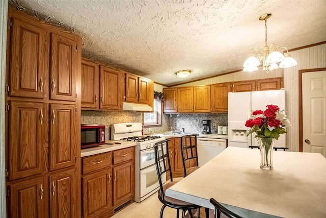 kitchen with ornamental molding, hanging light fixtures, white appliances, and an inviting chandelier