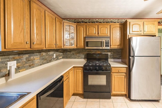 4164 Emily Dr, North East, PA 16428 - kitchen with appliances with stainless steel finishes, light tile patterned floors, decorative backsplash, and light countertops