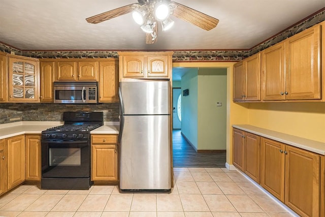 4164 Emily Dr, North East, PA 16428 - kitchen featuring appliances with stainless steel finishes, a ceiling fan, light tile patterned flooring, backsplash, and light countertops