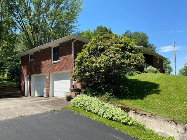 view of side of property featuring a garage and a yard