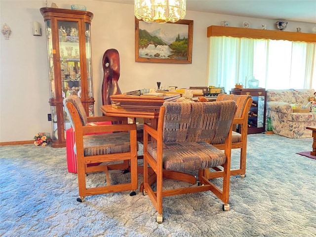 dining space with carpet floors and a chandelier