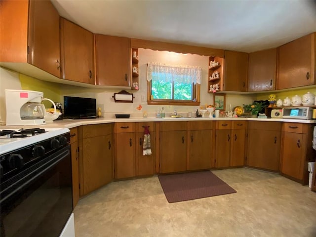 kitchen with white gas range and sink