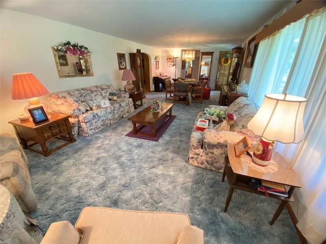 living room featuring a chandelier and dark carpet