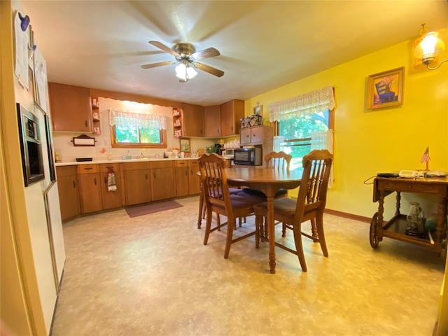 dining space with ceiling fan and sink