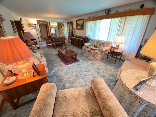 carpeted living room with an inviting chandelier