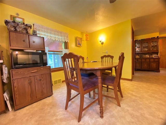 dining space featuring light colored carpet