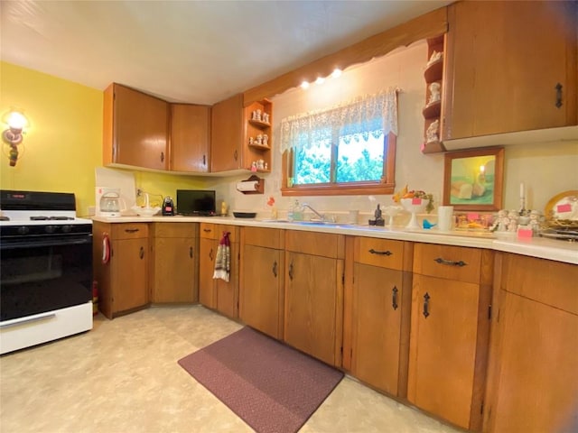 kitchen featuring white range with gas cooktop and sink