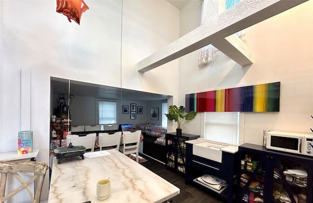 kitchen featuring dark hardwood / wood-style flooring and a towering ceiling