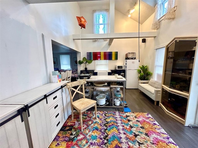 kitchen featuring white cabinets, dark hardwood / wood-style flooring, white appliances, and high vaulted ceiling