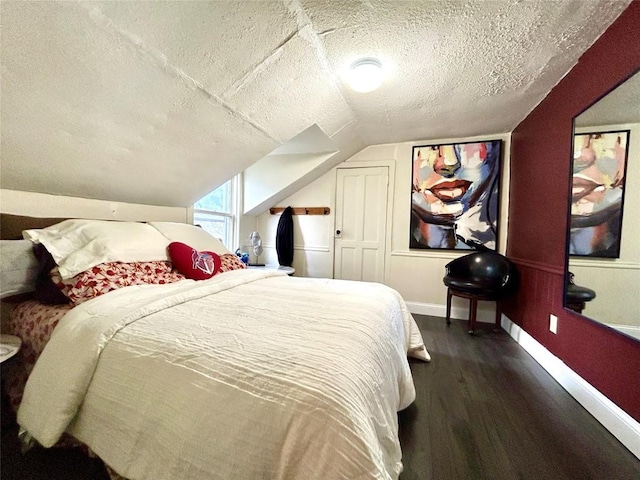 bedroom with a textured ceiling, vaulted ceiling, and dark wood-type flooring