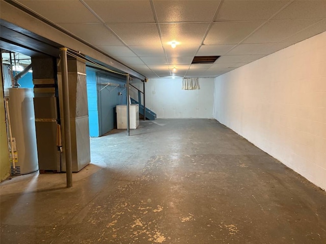 basement featuring a paneled ceiling and water heater