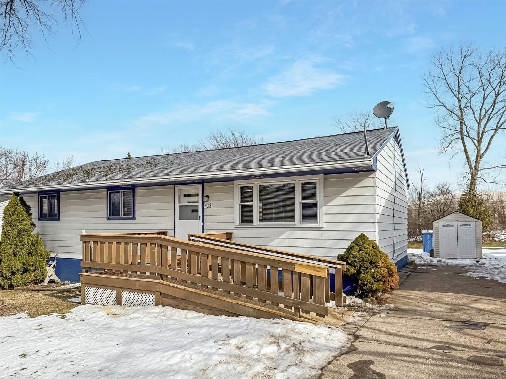 view of front of house with a deck and a shed