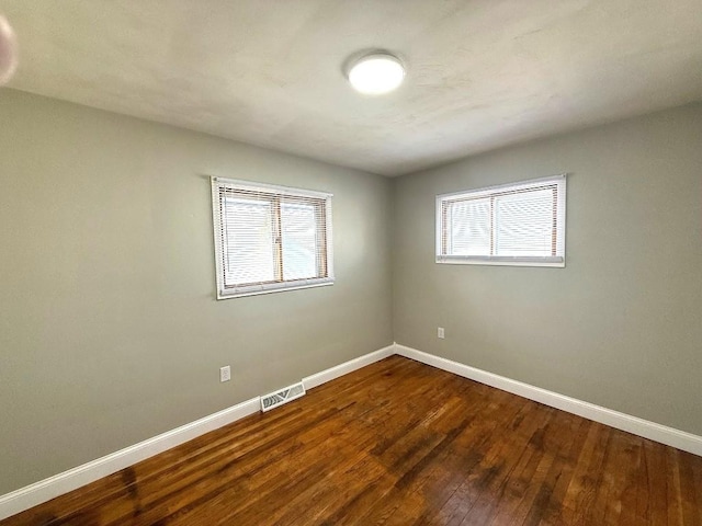 spare room featuring plenty of natural light and hardwood / wood-style floors