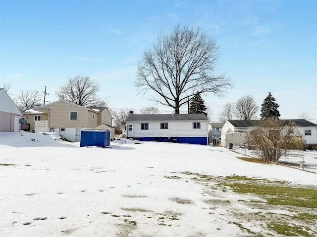 view of snow covered rear of property