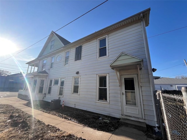 back of property featuring central air condition unit and fence