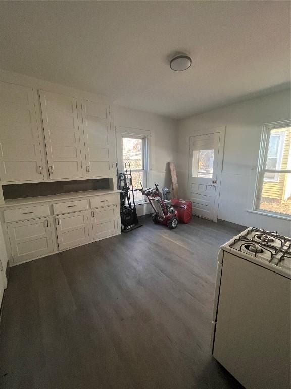 kitchen with white cabinetry, white range with gas cooktop, dark wood finished floors, and a healthy amount of sunlight