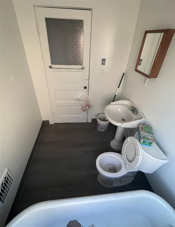 bathroom featuring visible vents, baseboards, and wood finished floors