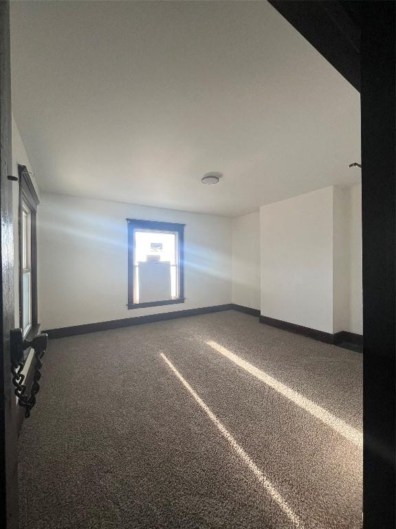 empty room featuring baseboards and carpet floors