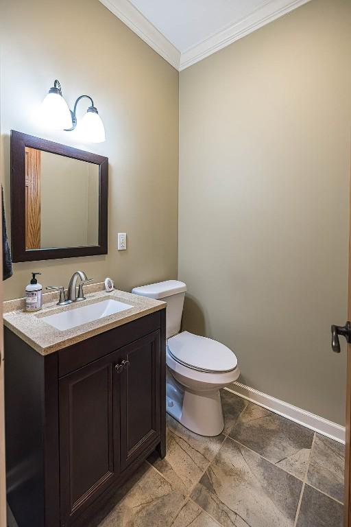21720 Matthew Ln, Saegertown, PA 16433 - bathroom with crown molding, toilet, vanity, and baseboards