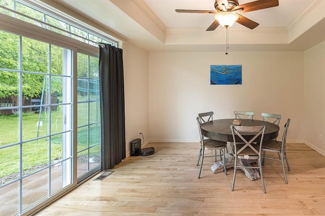 21720 Matthew Ln, Saegertown, PA 16433 - dining room featuring a raised ceiling, healthy amount of natural light, a ceiling fan, light wood finished floors, and crown molding