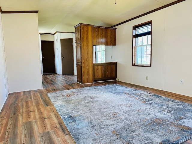 interior space featuring ornamental molding, brown cabinetry, and wood finished floors