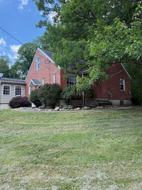 518 Spring St, Jamestown, PA 16134 - view of side of home featuring brick siding and a lawn