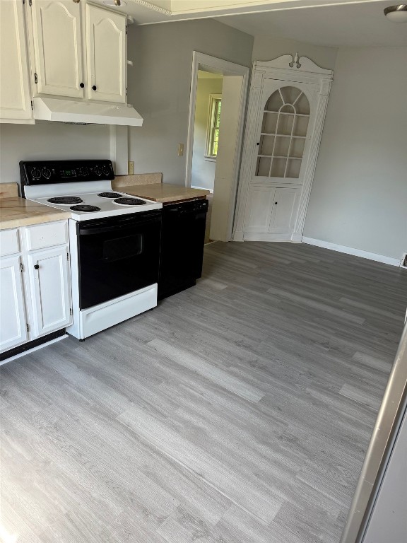 518 Spring St, Jamestown, PA 16134 - kitchen featuring electric range, under cabinet range hood, dishwasher, light countertops, and white cabinets