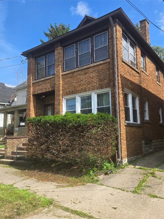 327 E 7th St, Erie, PA 16503 - view of front of house with a chimney and brick siding