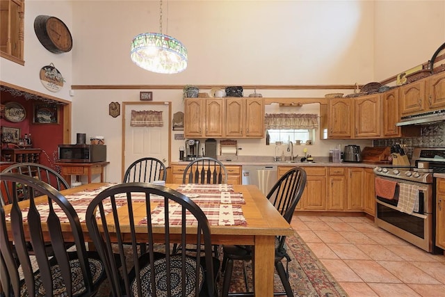 38753 Centerville Rd, Centerville, PA 16404 - kitchen featuring a towering ceiling, stainless steel appliances, under cabinet range hood, a chandelier, and light countertops