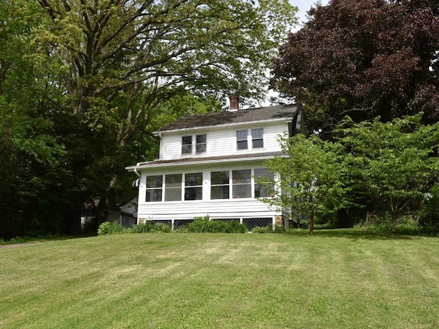 9954 Liberty Ext, Meadville, PA 16335 - back of house with a chimney, a lawn, and a sunroom