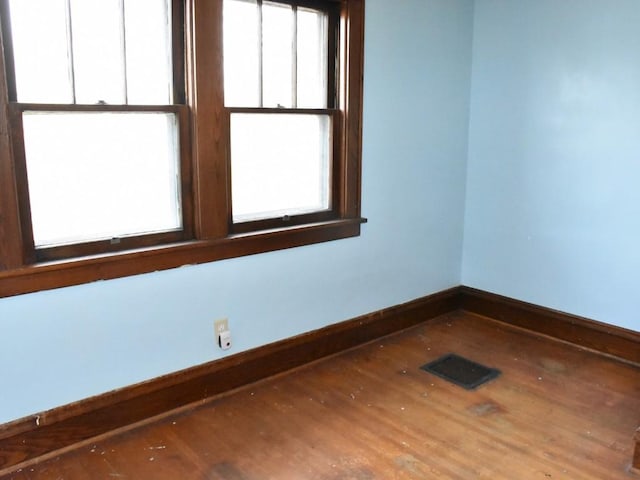 spare room featuring visible vents and wood finished floors