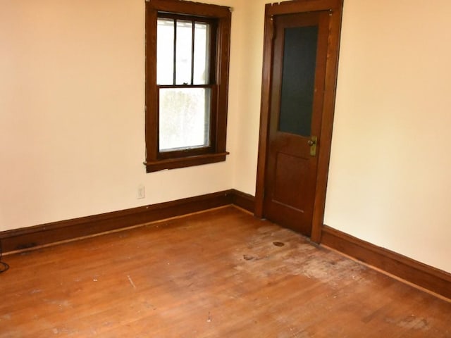 unfurnished room with baseboards and wood finished floors