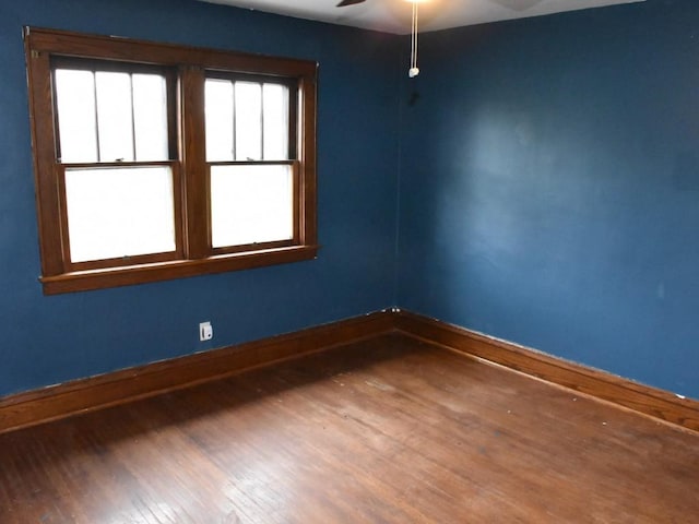 unfurnished room with a ceiling fan, baseboards, and wood finished floors