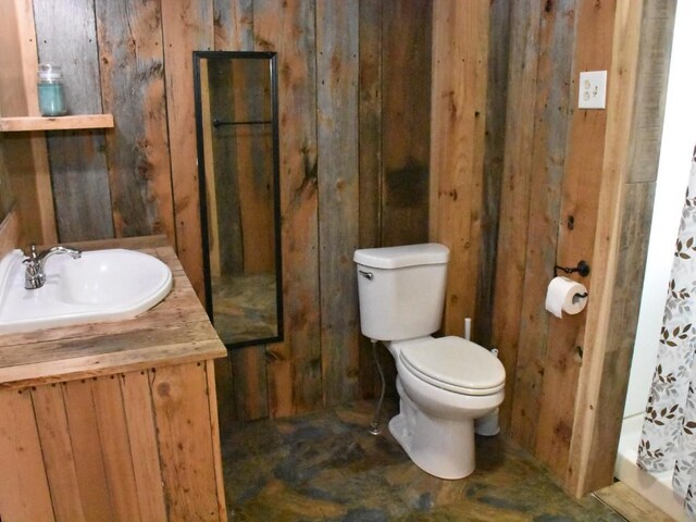 full bathroom with toilet, wood walls, walk in shower, and vanity