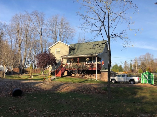 rear view of house with covered porch and a yard