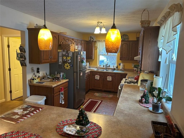 10492 Mohawk Rd, Conneaut Lake, PA 16316 - kitchen with freestanding refrigerator, white gas stove, hanging light fixtures, light countertops, and a textured ceiling