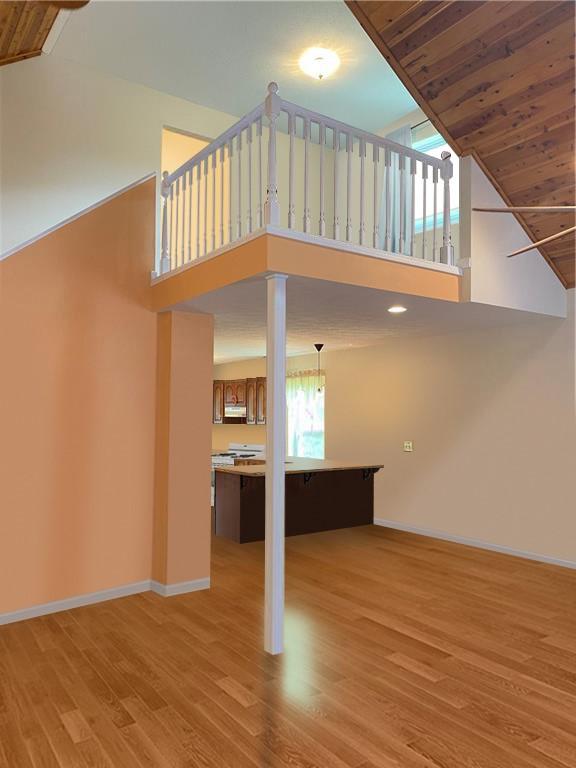 unfurnished living room featuring light wood-type flooring, high vaulted ceiling, and wood ceiling