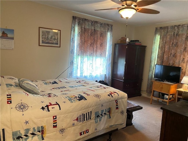 bedroom featuring multiple windows, ceiling fan, and light colored carpet