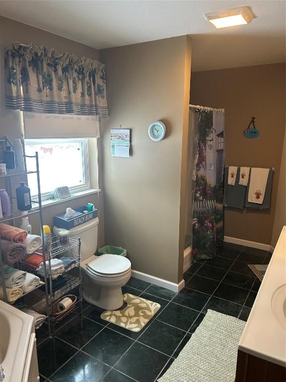 bathroom with a shower with shower curtain, vanity, toilet, and tile patterned floors